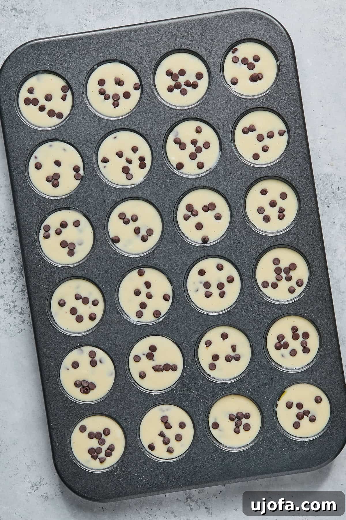 Mini muffin cups filled almost to the top and topped with extra chocolate chips