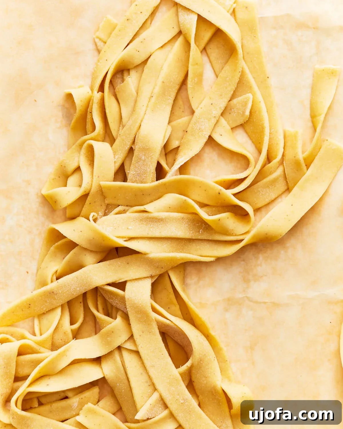 Freshly cut gluten-free egg noodles laid out on parchment paper, ready to be cooked or frozen.