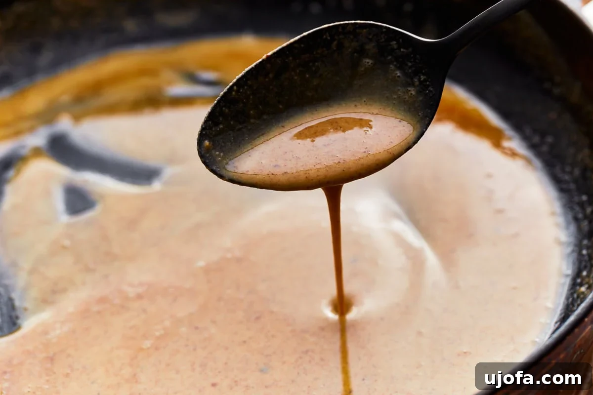 Mastering Gluten-Free Roux 4 A spoon scooping gluten-free roux from a skillet.