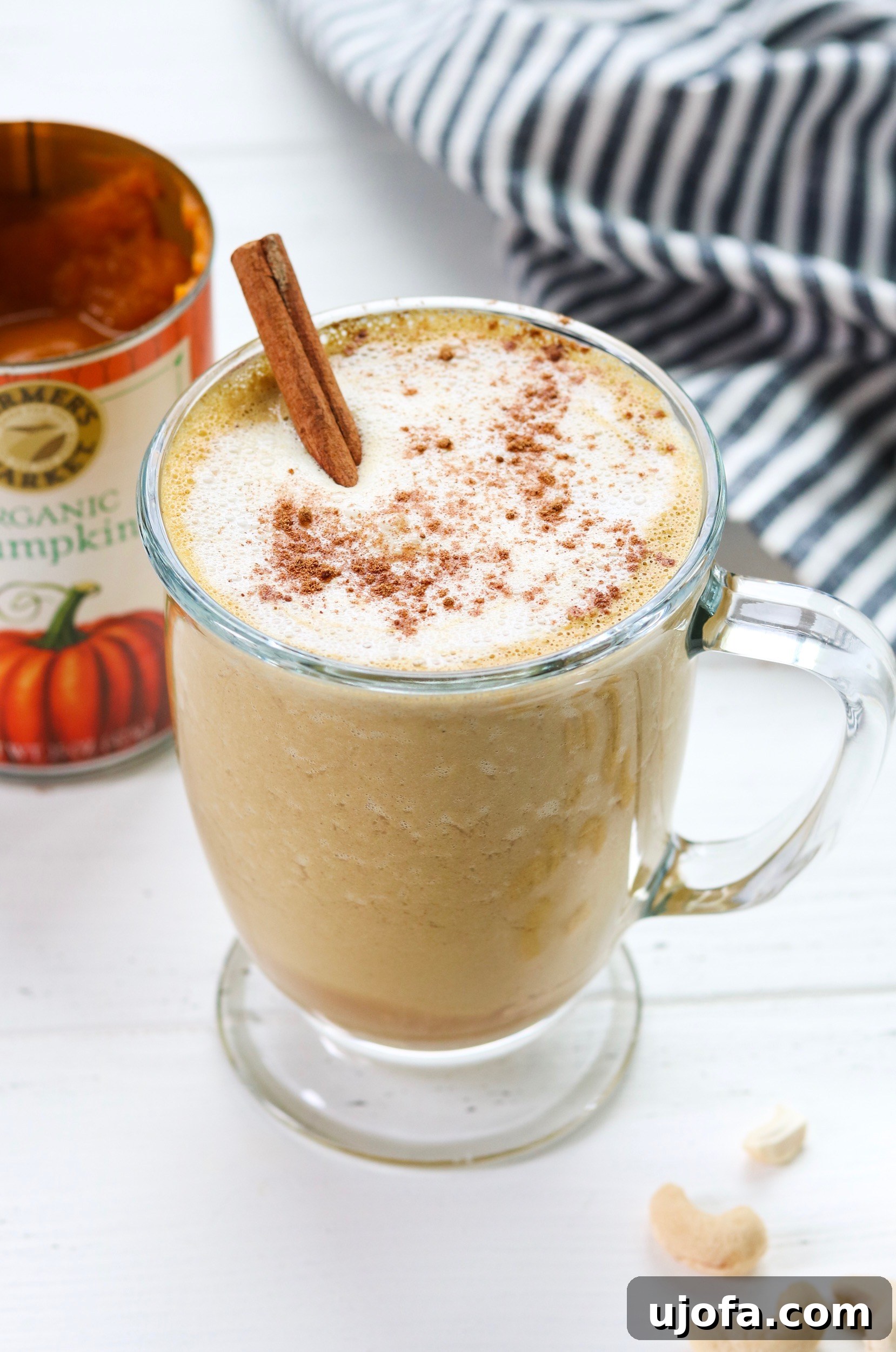 Ingredients for Creamy Cashew Pumpkin Spice Latte laid out on a wooden table.