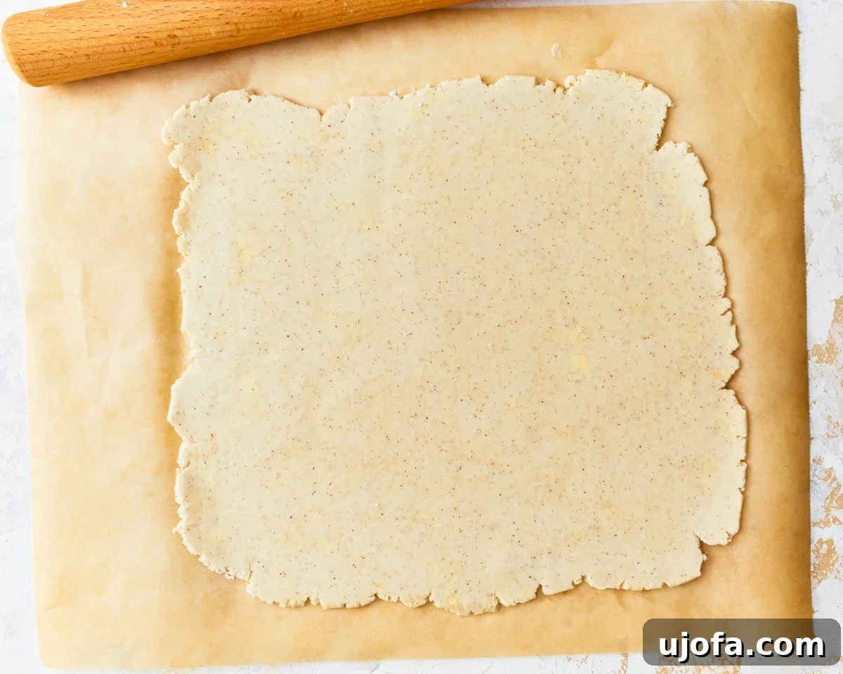 Buttery Golden Gluten-Free Crackers 11 Gluten-free ritz cracker dough evenly rolled out into a thin rectangle on a sheet of parchment paper.