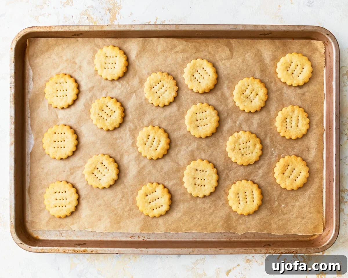Buttery Golden Gluten-Free Crackers 14 Freshly baked homemade gluten-free ritz crackers, golden brown and crisp, cooling on a parchment-lined baking sheet.