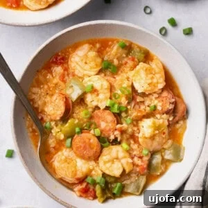 Instant Pot Jambalaya Soup in a bowl with a spoon topped with green onions