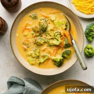 broccoli cheddar soup made in the instant pot in bowls with a spoon and a bowl of cheese on the side