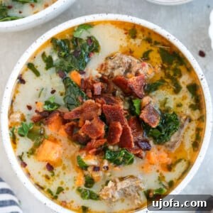 Whole30 Zuppa Toscana in a white bowl topped with bacon and parsley