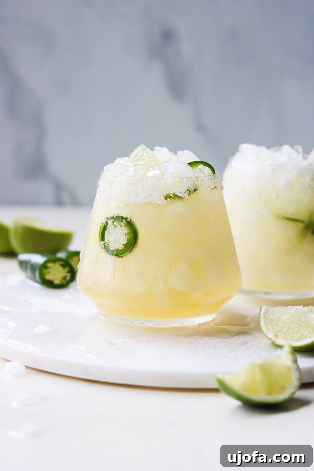 Spicy Paleo Jalapeno Margarita in a salt-rimmed glass, garnished with a lime wedge and jalapeno slice.