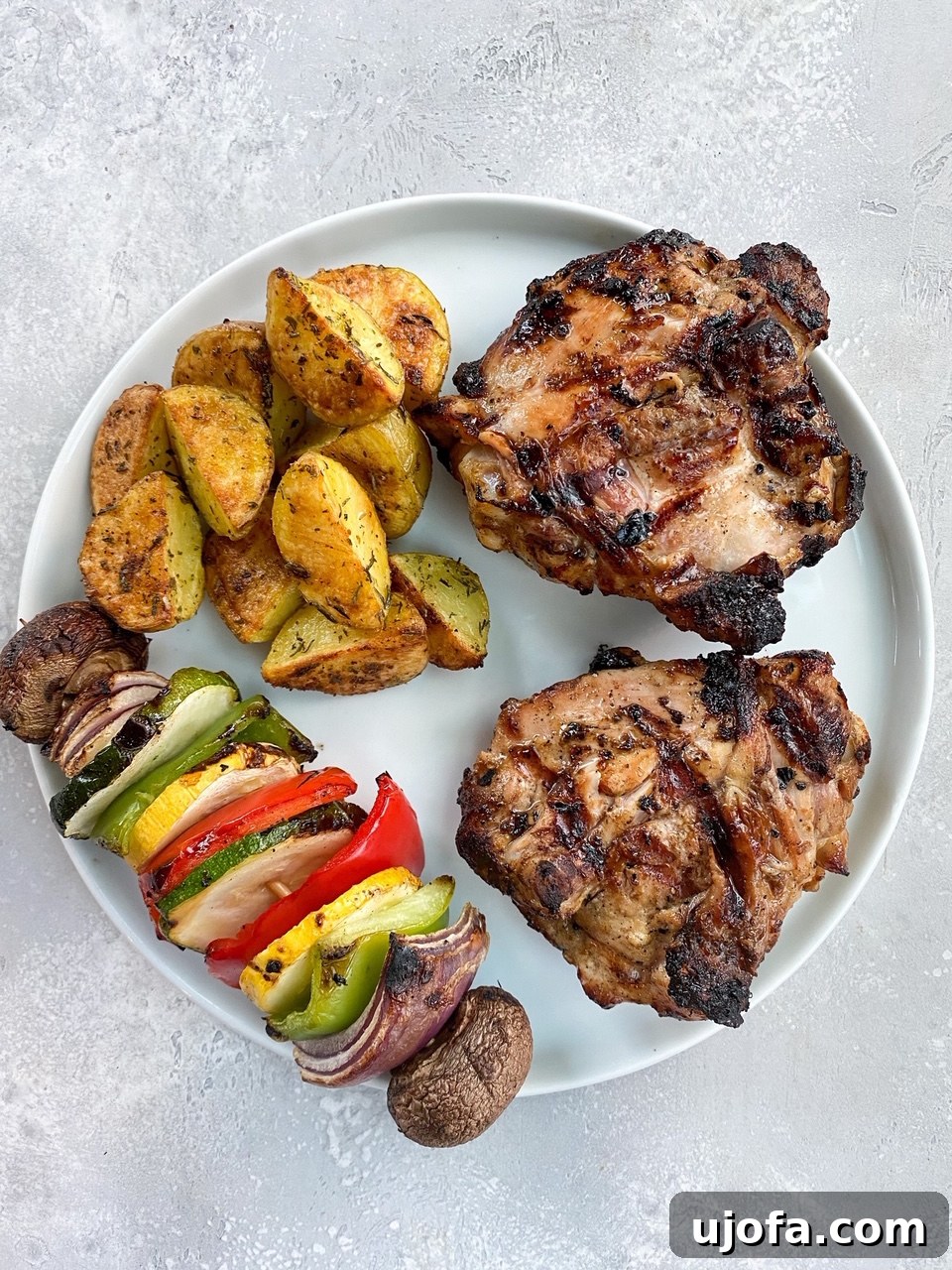 Perfectly grilled Whole30 chicken thighs with a golden-brown sear, resting on a serving platter.