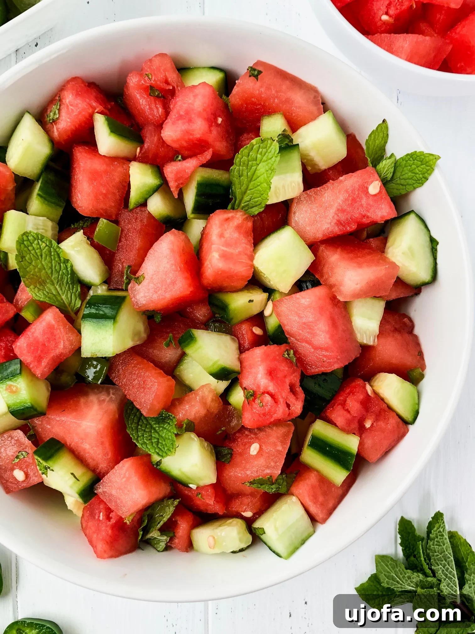 Refreshing Whole30 Watermelon Cucumber Salad with fresh mint leaves and a light dressing.