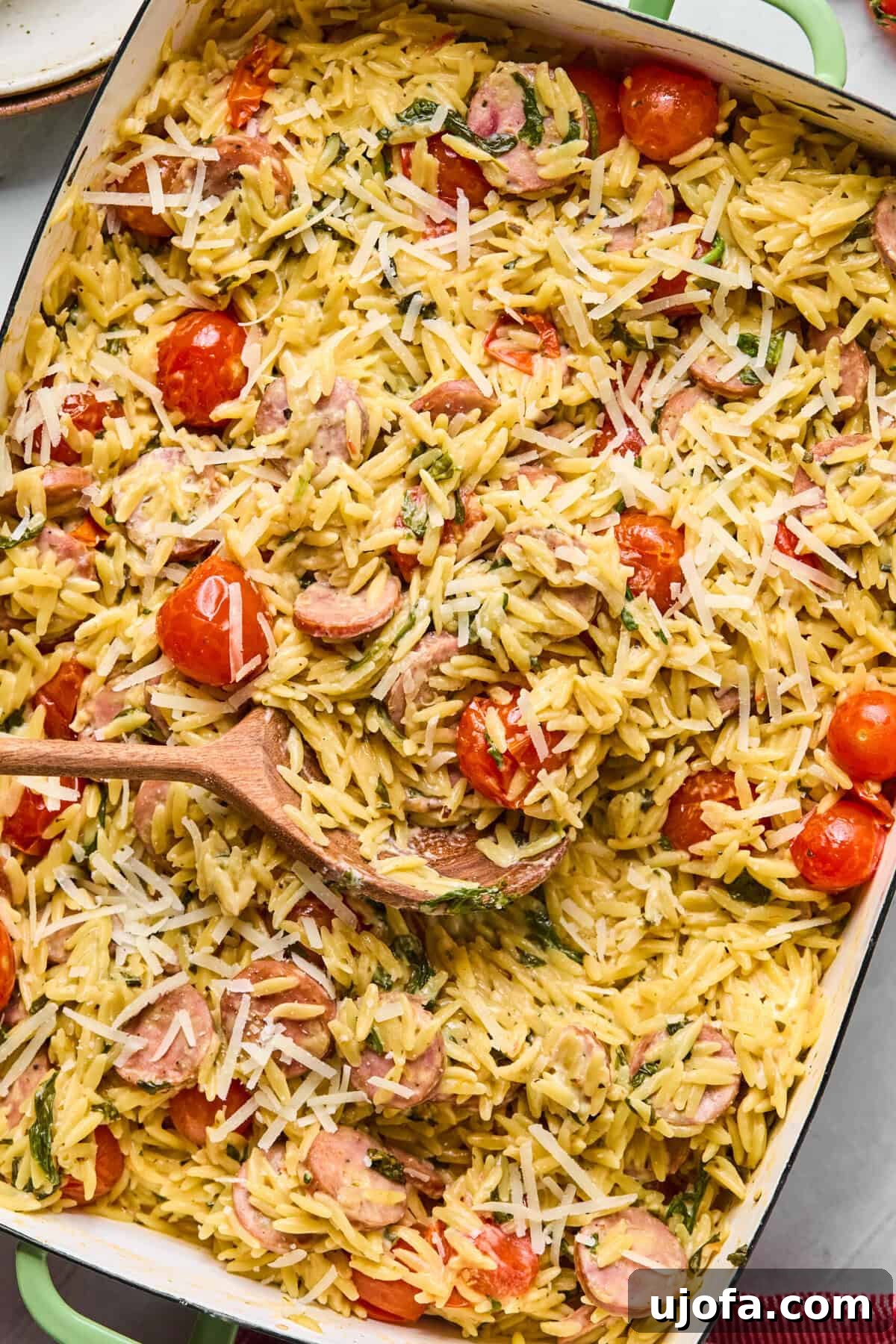 Kremamsı Boursin Orzo Tavuk Sosisli Tek Tencere Keyfi 2 Baked one pan orzo with chicken sausage, cherry tomatoes, and spinach in a white baking dish, ready to serve.