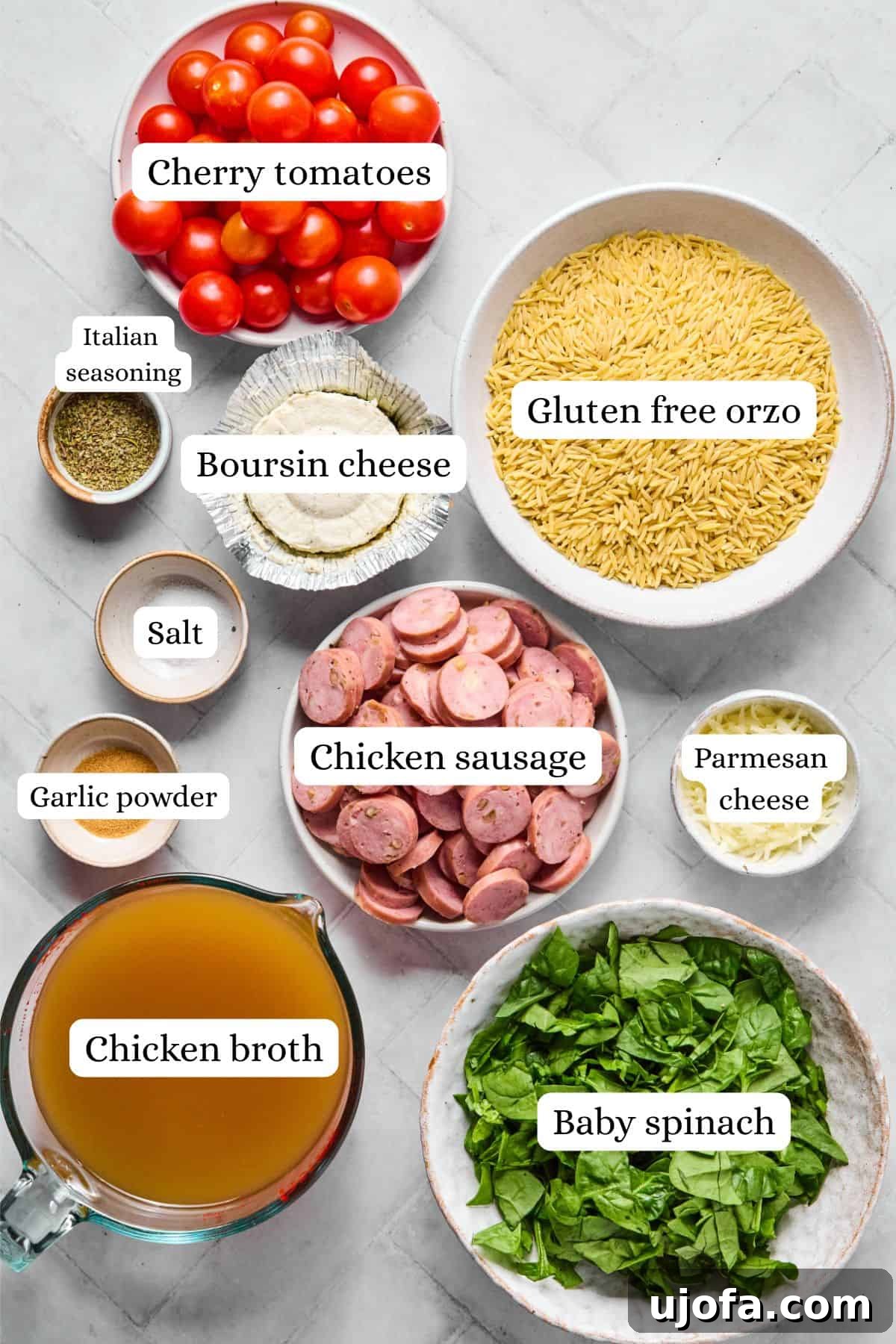 Kremamsı Boursin Orzo Tavuk Sosisli Tek Tencere Keyfi 3 Ingredients for one pan orzo bake including Boursin cheese, gluten-free orzo, chicken sausage, spinach, and cherry tomatoes laid out on a kitchen counter.