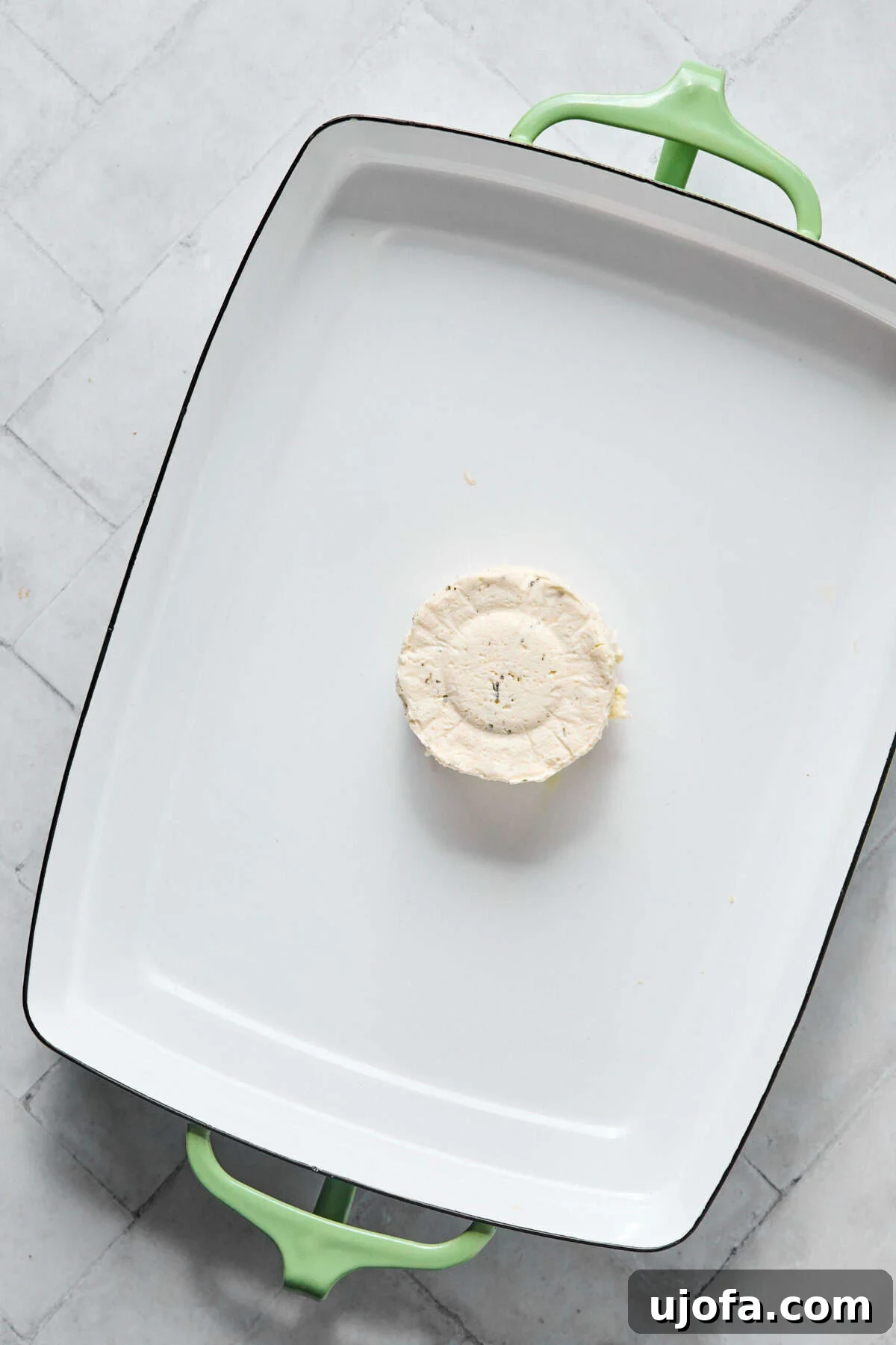 Kremamsı Boursin Orzo Tavuk Sosisli Tek Tencere Keyfi 4 Boursin cheese placed in the center of a white rectangular baking dish before adding other ingredients.