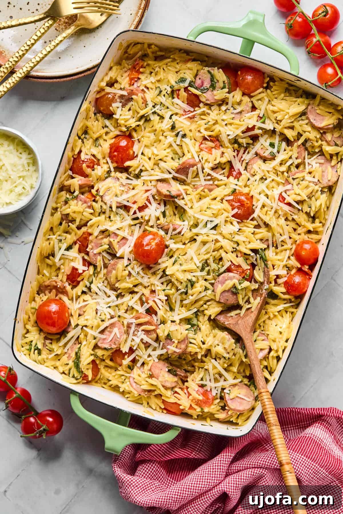 Kremamsı Boursin Orzo Tavuk Sosisli Tek Tencere Keyfi 8 Finished baked orzo topped with a generous amount of melted Parmesan cheese, garnished with fresh herbs, ready to be served.