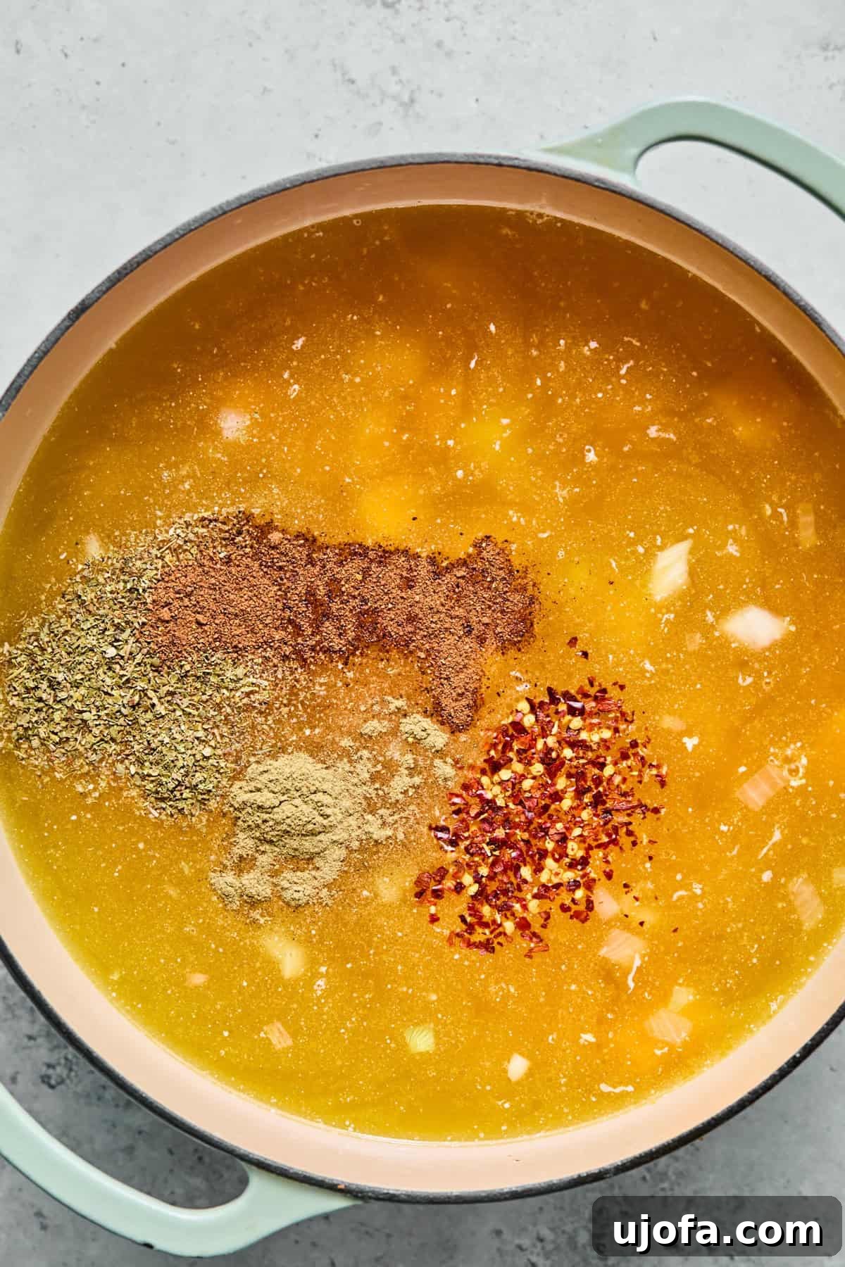 Comforting Butternut Squash Lasagna Soup 6 Cubed butternut squash simmering in a pot of chicken broth with various seasonings, nearing the point of becoming fork-tender.