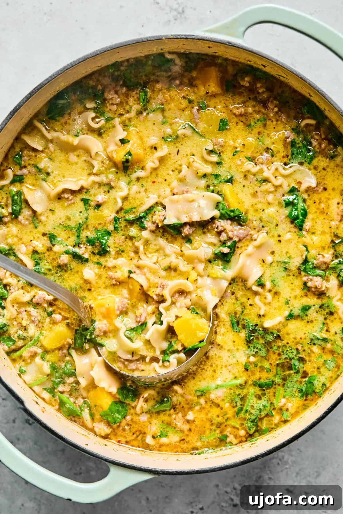 Comforting Butternut Squash Lasagna Soup 9 A large pot filled with rich butternut squash lasagna soup, a ladle resting inside, ready to be served into individual bowls.