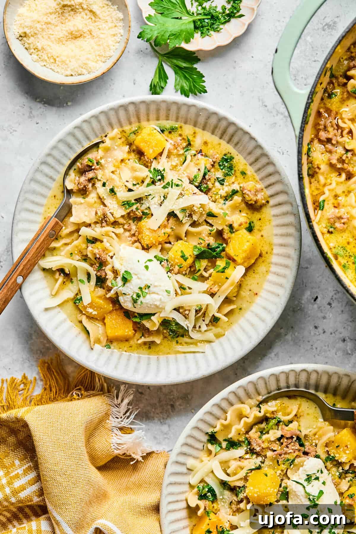 Comforting Butternut Squash Lasagna Soup 10 A close-up, inviting shot of a bowl brimming with hearty butternut squash lasagna soup, showcasing the noodles, crumbled sausage, and luscious melted cheese.
