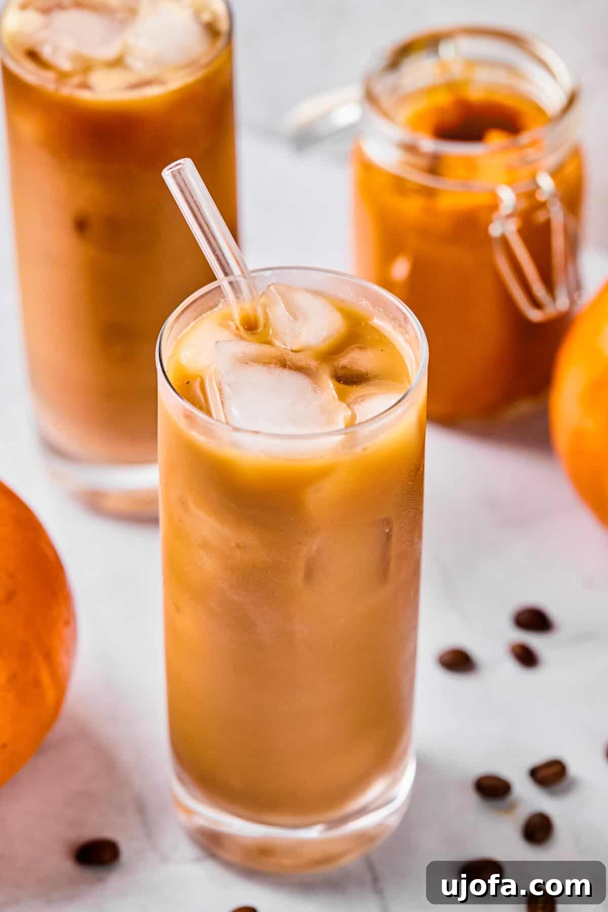 A vibrant glass of protein pumpkin cold brew, featuring distinct layers of dark coffee and creamy, orange cold foam, garnished with a sprinkle of spice, emphasizing its delicious appeal.