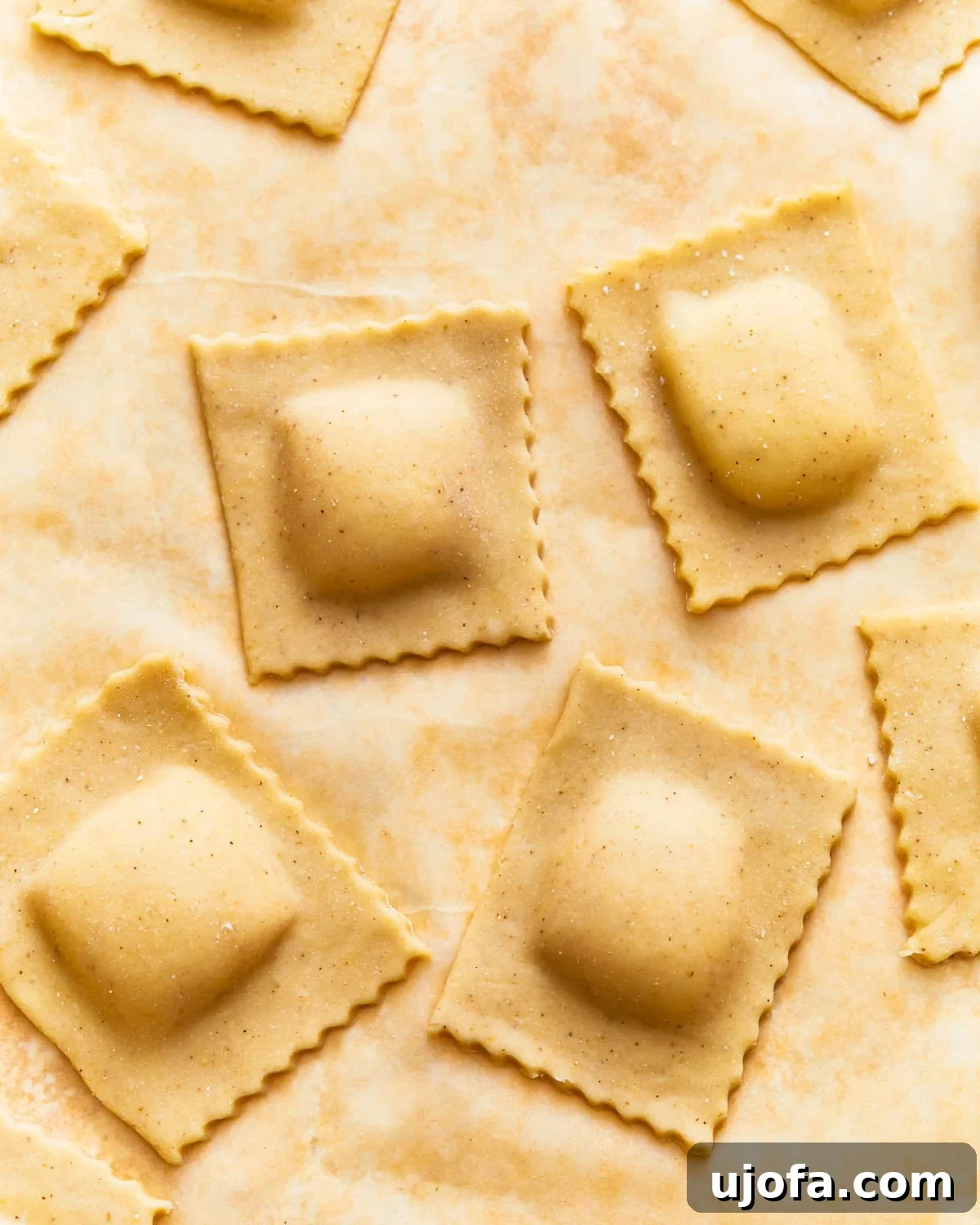 Uncooked gluten-free ravioli on parchment paper.