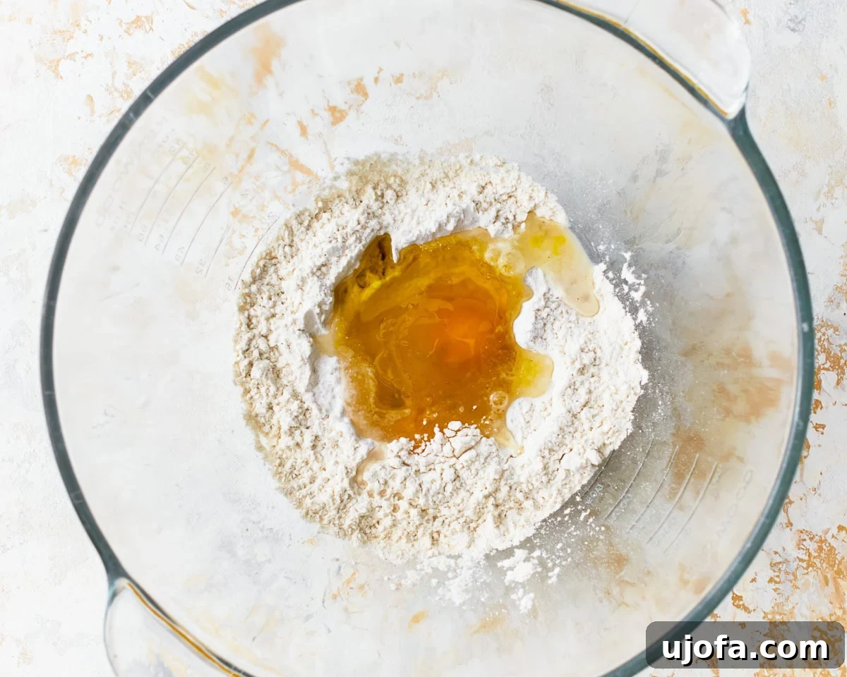 Eggs added to dry ingredients for gluten-free ravioli in a glass mixing bowl.