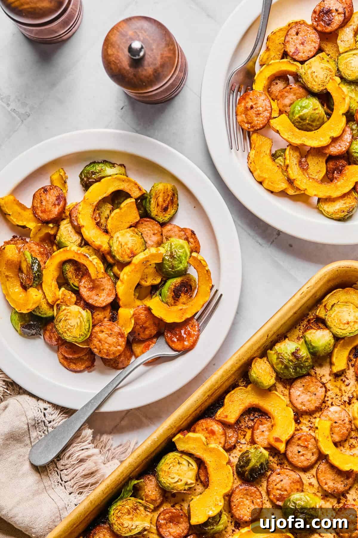 Sheet Pan Roasted Delicata Squash and Chicken Sausage 2 Two plates featuring a vibrant harvest sheet pan dinner with roasted delicata squash, chicken sausage, and Brussels sprouts.