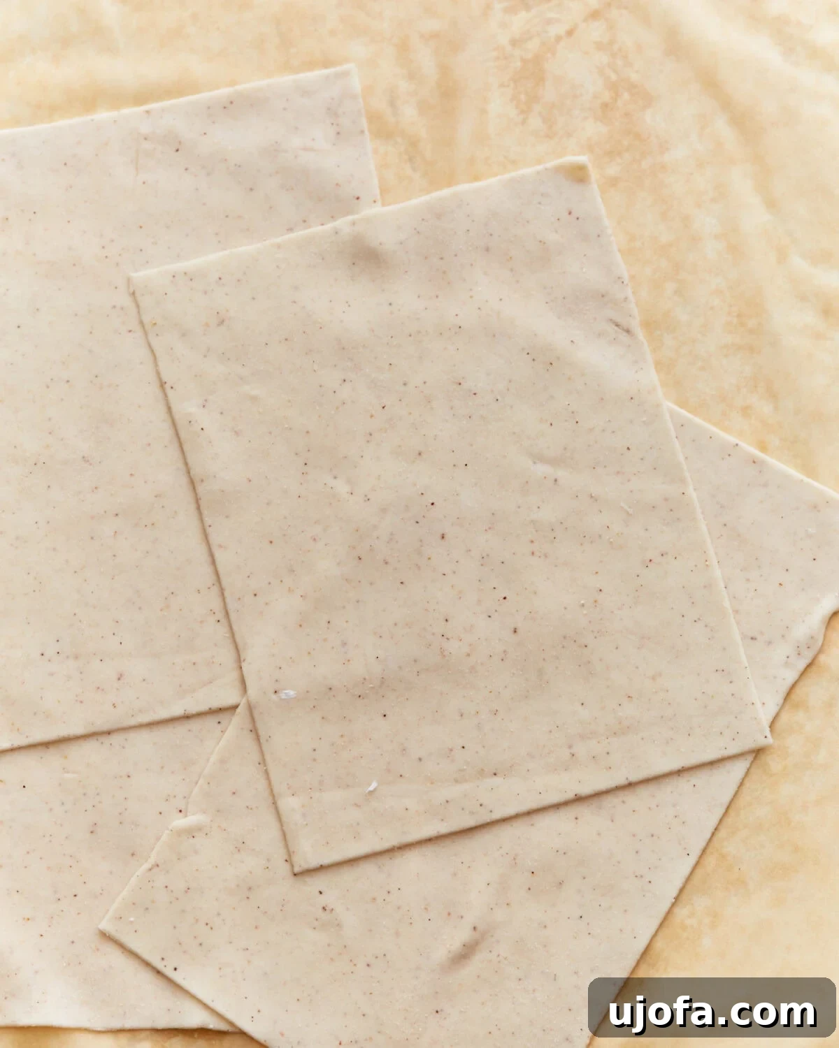 Delicately layered sheets of gluten-free phyllo dough resting on parchment paper, ready for culinary creation.
