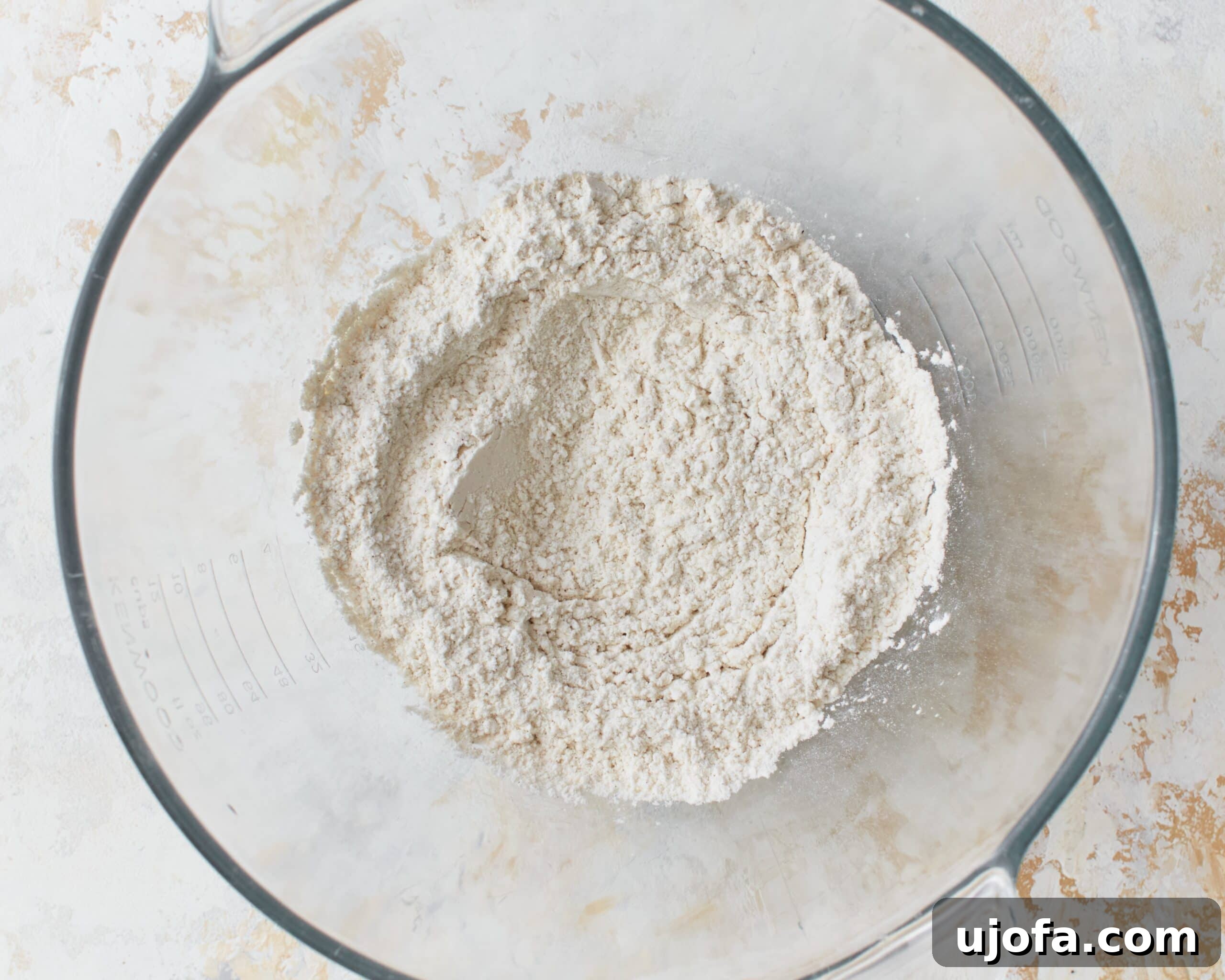 Dry ingredients for gluten-free phyllo dough carefully measured in a glass mixing bowl.