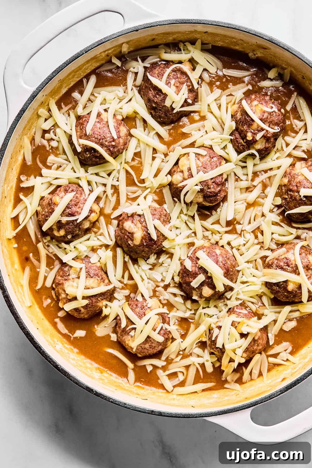 Savory French Onion Meatballs with Rich Gravy 10 Cooked meatballs gently nestled into the rich onion gravy in the large oven-safe skillet, with shredded Gruyère cheese sprinkled generously over them.