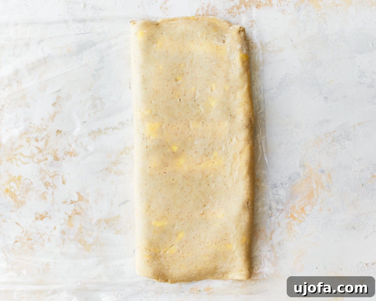 Gluten-free puff pastry dough fully folded into a rectangle with visible butter flecks, completing the second turn.