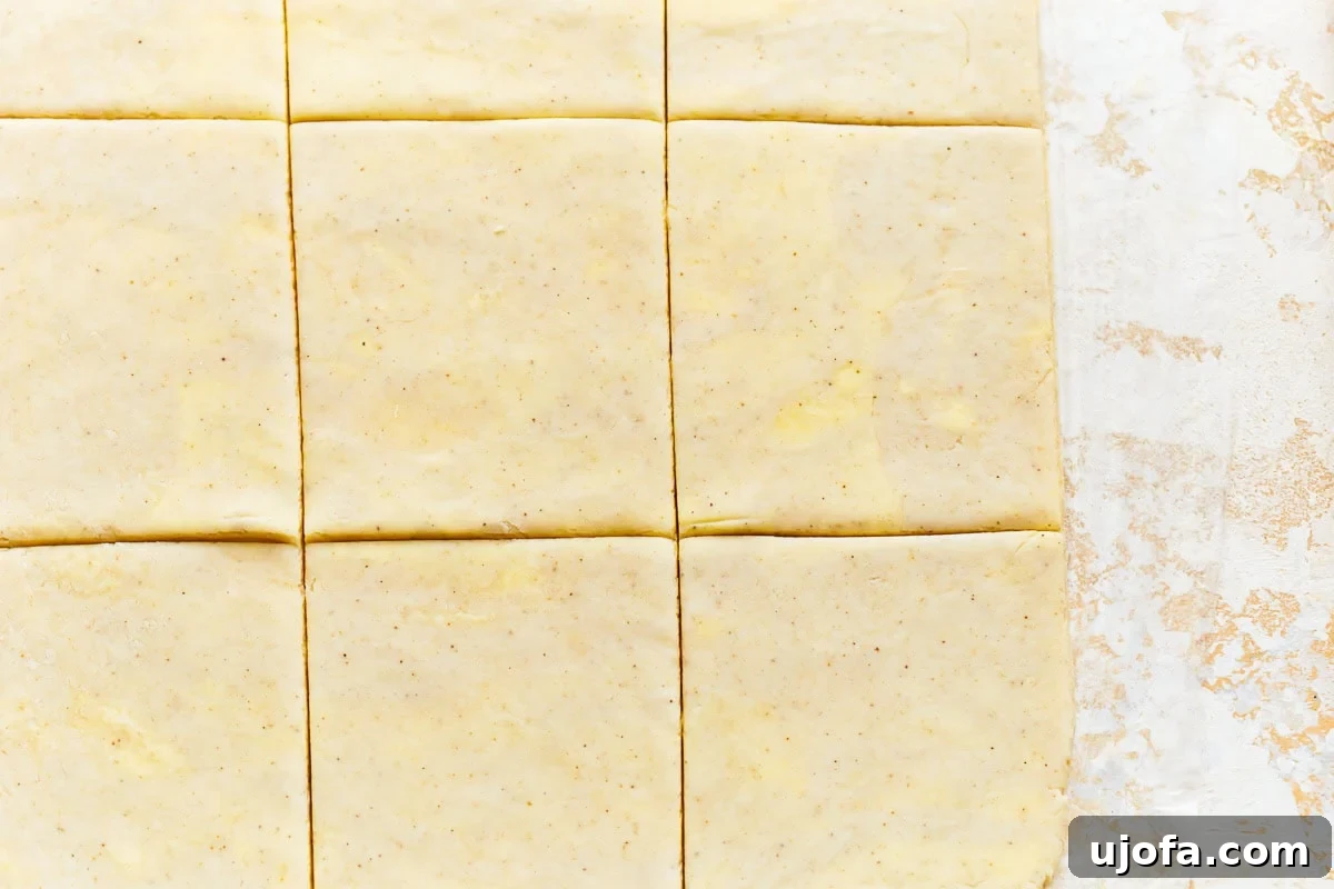 Close-up of gluten-free puff pastry dough cut into squares, showing off the internal layers before baking.