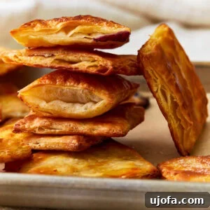 Side view of gluten-free puff pastry squares stacked on top of each other, showcasing their height and flakiness.