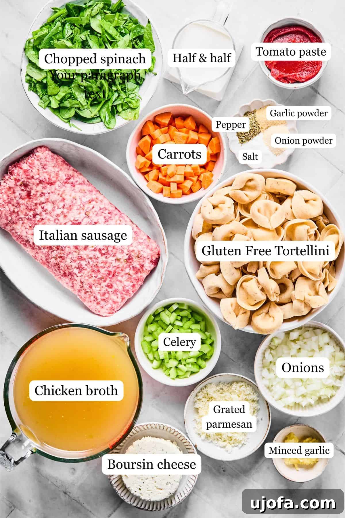 A vibrant display of fresh ingredients for creamy sausage tortellini soup, including spinach, carrots, Italian sausage, tortellini, various seasonings, half and half, tomato paste, Boursin cheese, chicken broth, celery, onions, and garlic.