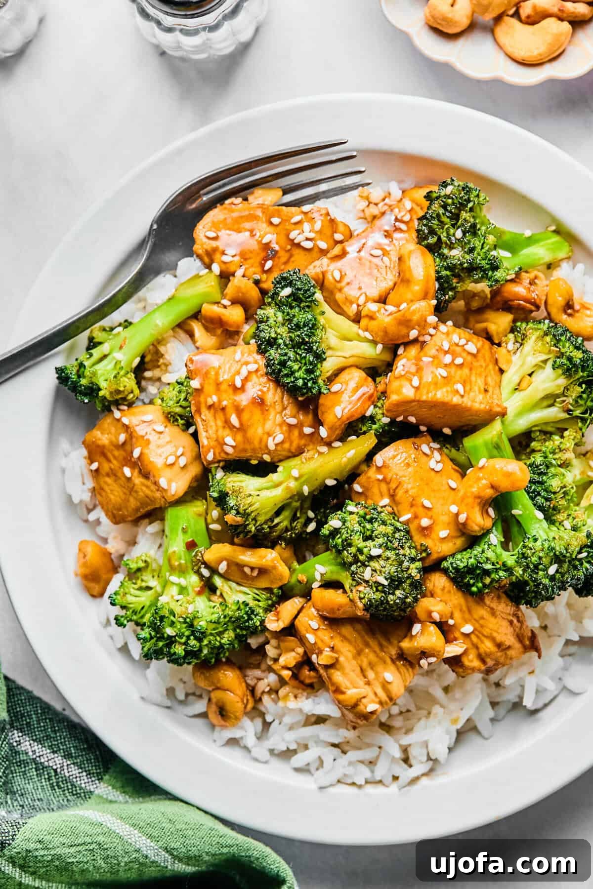 Speedy Chicken and Broccoli Stir-Fry 2 Chicken broccoli stir fry on a bed of rice garnished with sesame seeds.