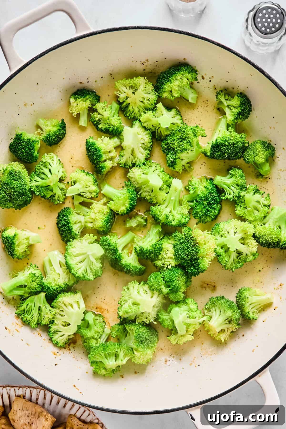 Speedy Chicken and Broccoli Stir-Fry 6 Broccoli florets steaming with a splash of water in a large sauté pan.