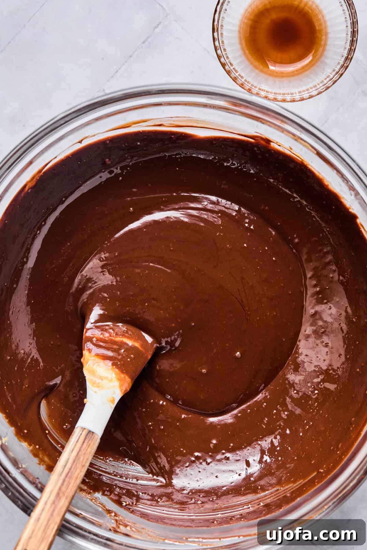 Melted chocolate chips, peanut butter, butter, and vanilla in a glass bowl.