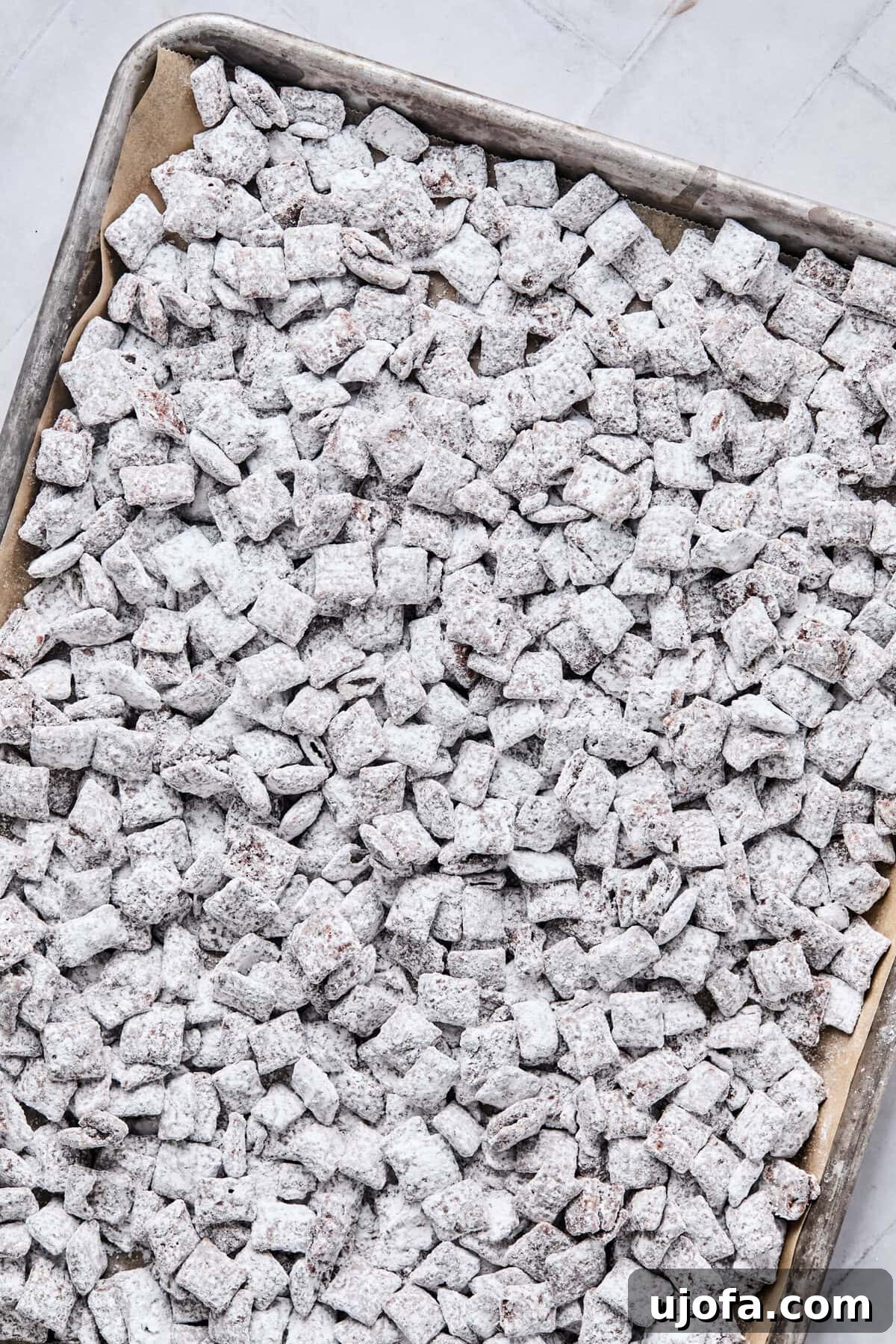 Cereal mixture spread onto a parchment-lined baking sheet.