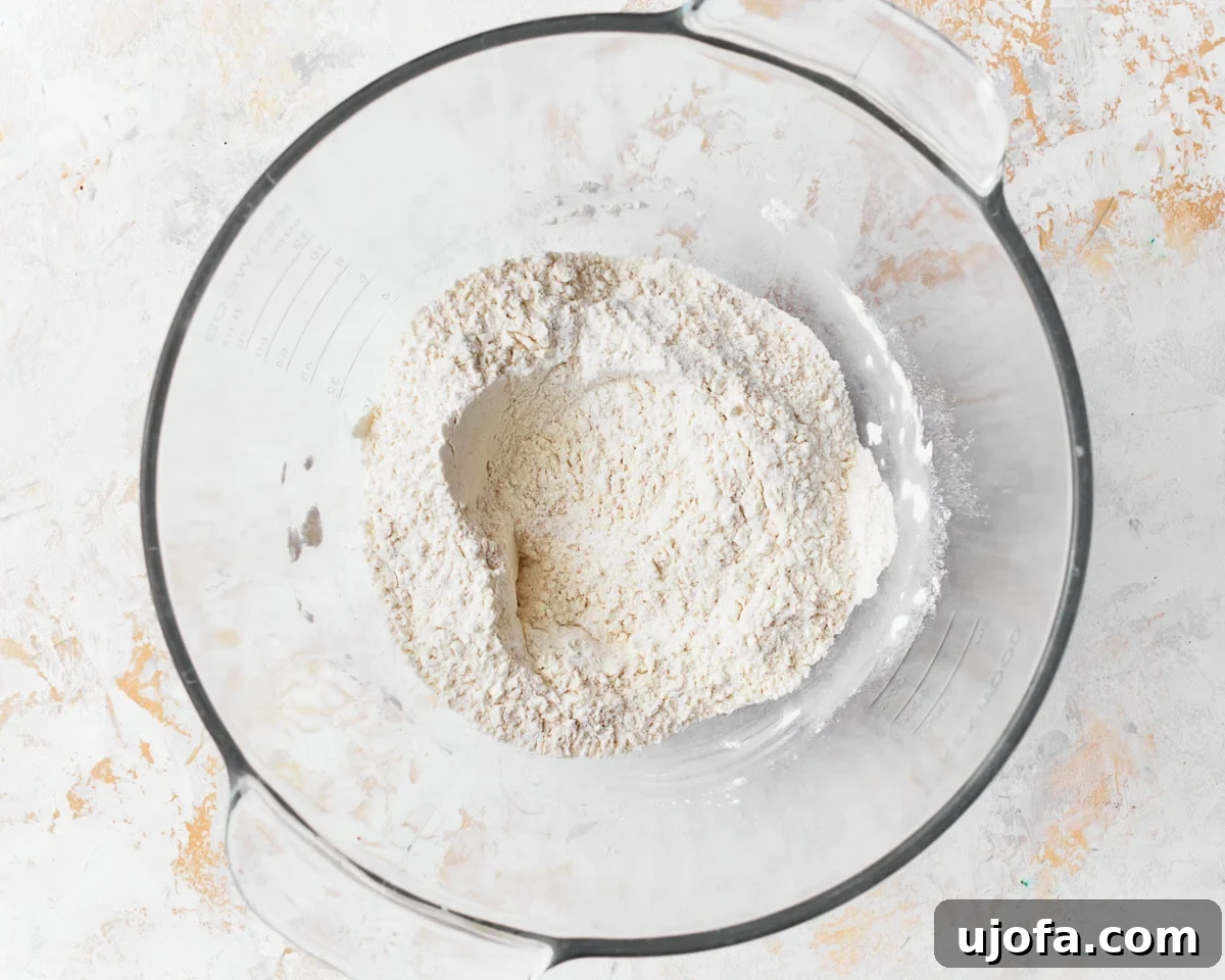 Dry ingredients for gluten-free challah bread in a glass mixing bowl.