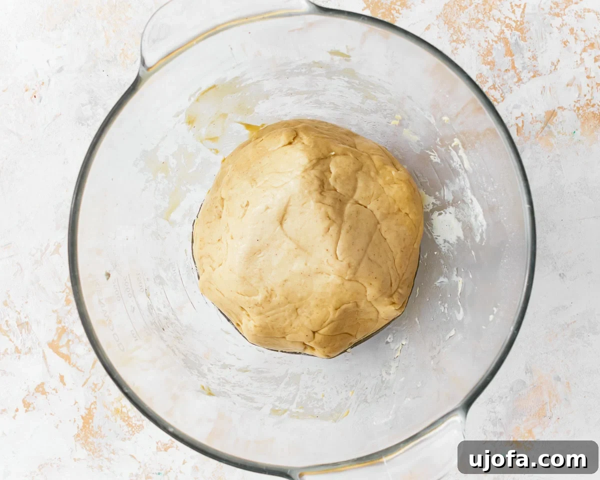 The dough for gluten-free challah bread after the first proof in a glass mixing bowl.