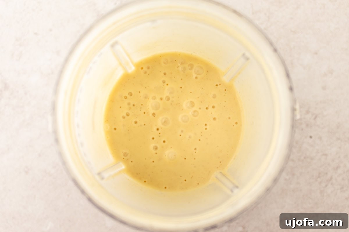 Wet ingredients for gluten-free popovers mixed in a blender, forming a smooth batter.