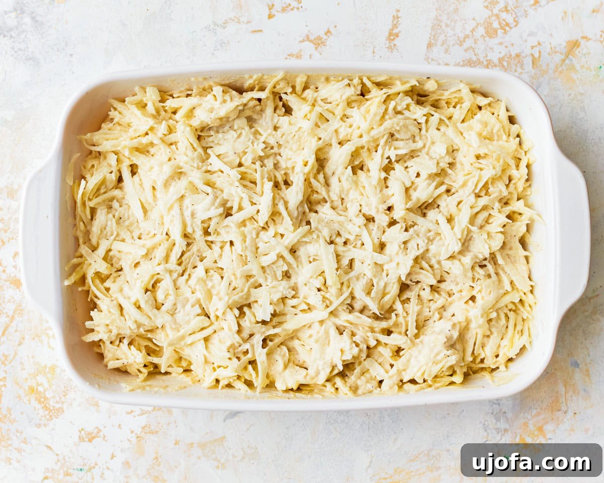 Yalancı Peynirli Patates 7 Grated potatoes with cashew sauce in a baking dish.