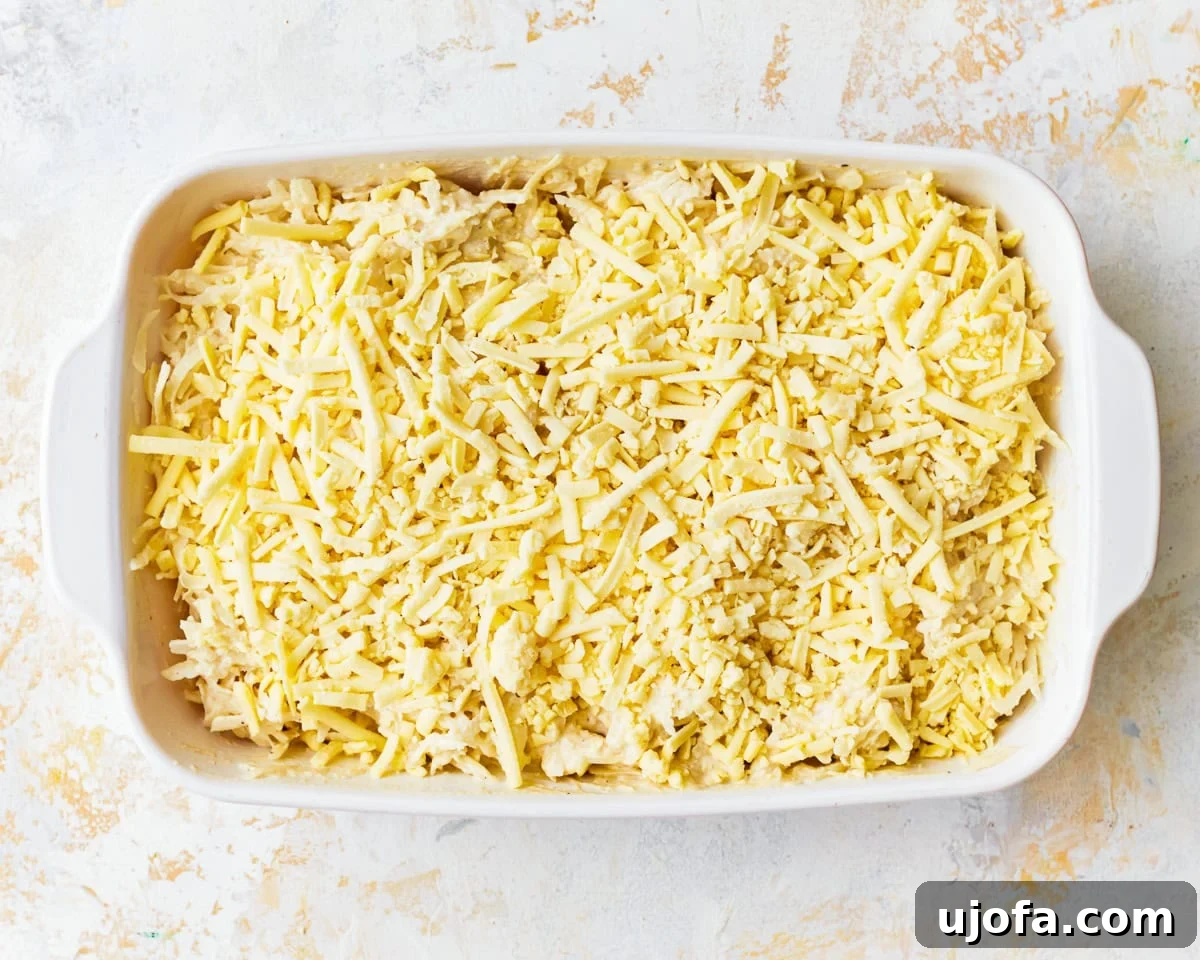 Yalancı Peynirli Patates 8 Grated potatoes in a baking dish covered in vegan cheese.