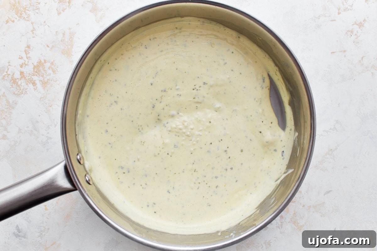 Decadent Gluten Free Boursin Pasta 9 An overhead view of cheese sauce in a silver saucepan