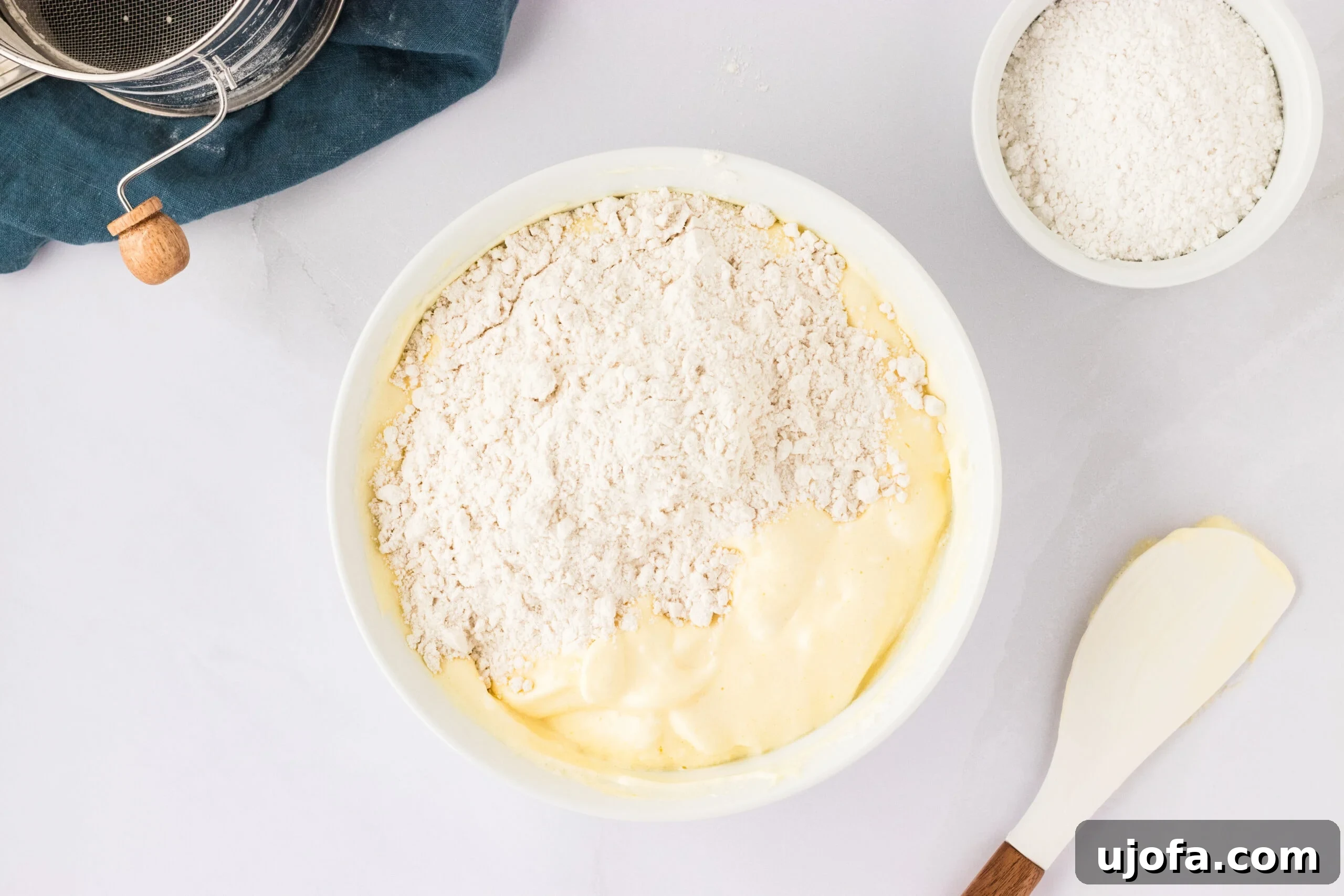 The Ultimate Gluten-Free Ladyfingers 14 flour on top of white bowl with egg mixture