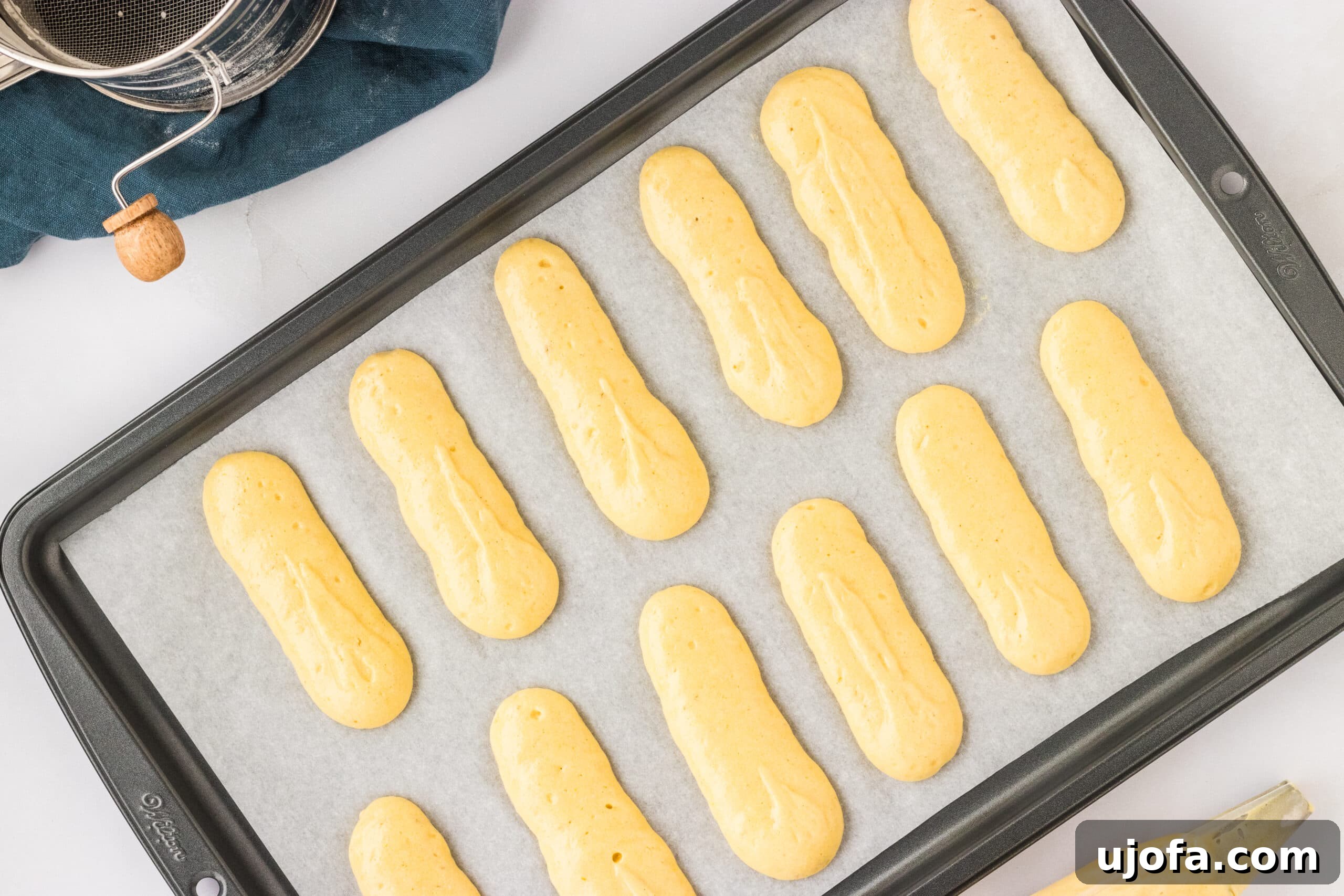 The Ultimate Gluten-Free Ladyfingers 16 uncooked ladyfinger dough lined up on lined baking sheet