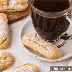 The Ultimate Gluten-Free Ladyfingers 6 black coffee in a clear mug, on a white saucer with a ladyfinger on it
