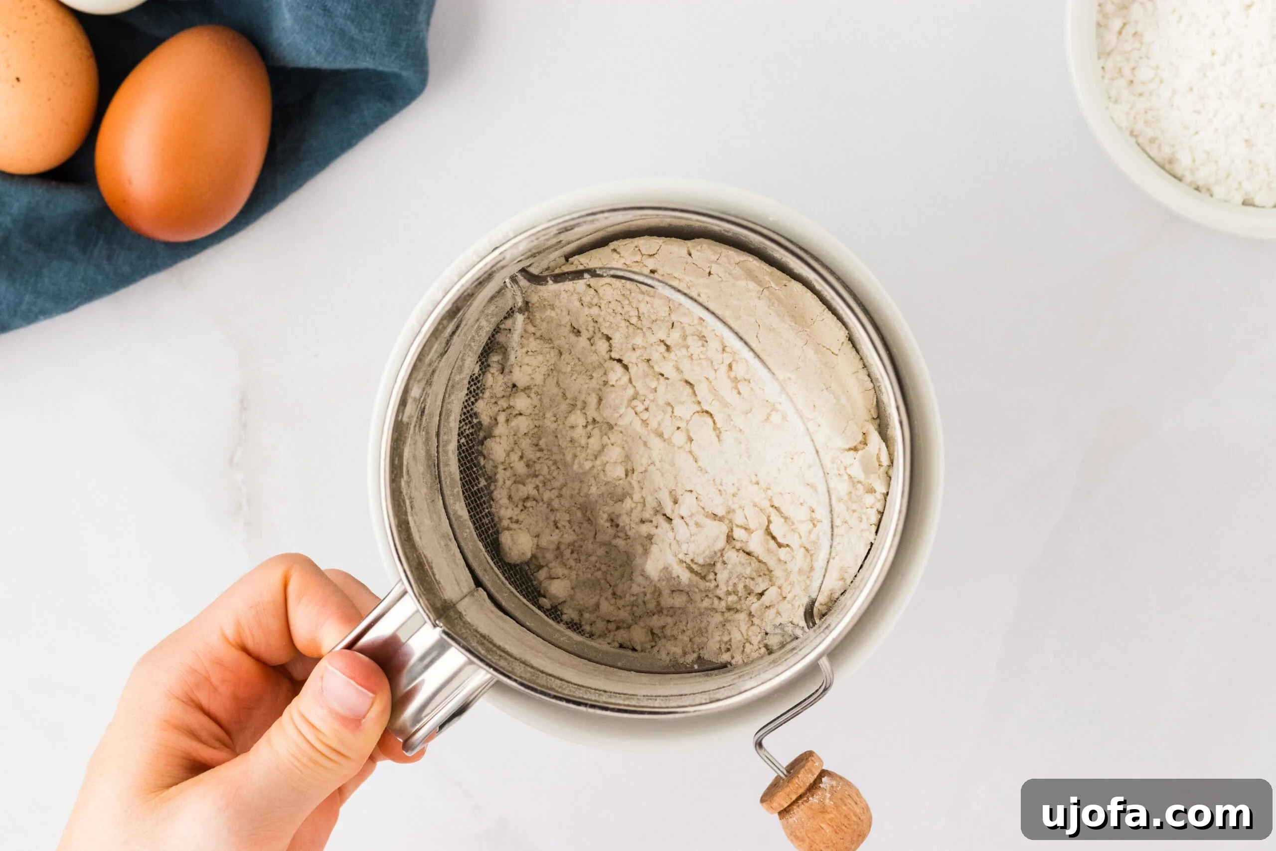 The Ultimate Gluten-Free Ladyfingers 8 flour mixture in sieve help in hand over white counter