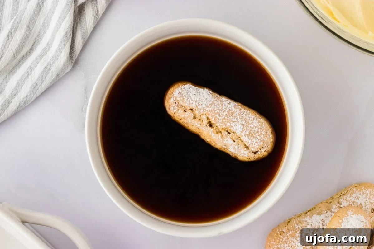 ladyfinger floating in coffee in white bowl