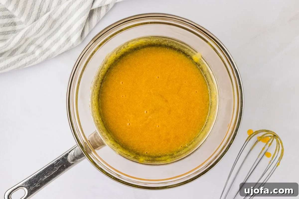 egg yolk mixture in glass bowl over metal pan