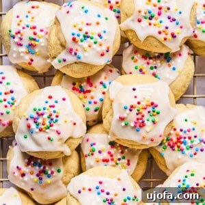 Italian wedding cookies with sprinkles piled on a cooling rack