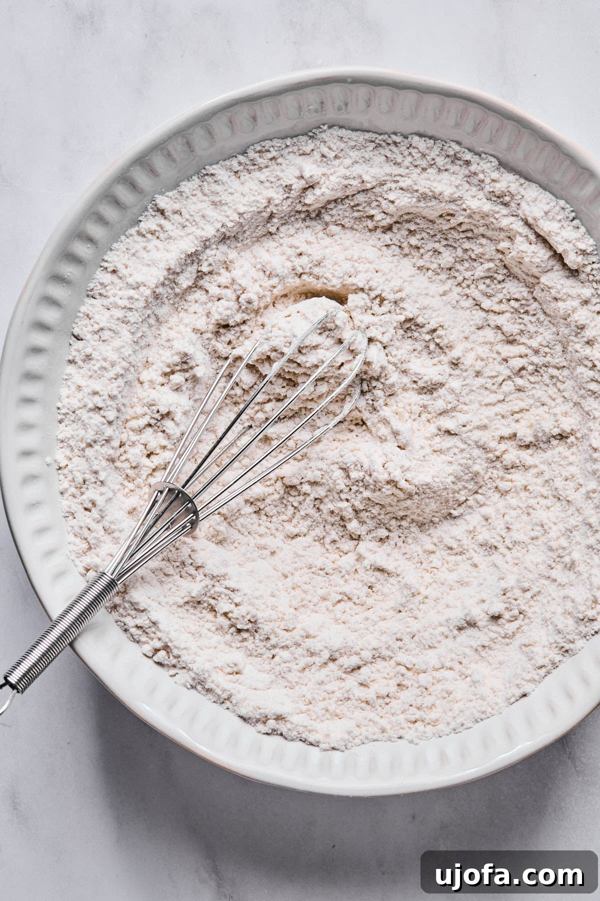 Sweet Traditions: Gluten-Free Italian Wedding Cookies 4 A medium bowl with gluten-free flour, baking powder, and salt mixed together.