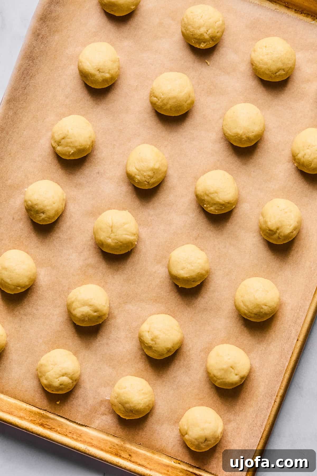 Sweet Traditions: Gluten-Free Italian Wedding Cookies 8 Italian wedding cookie dough rolled into 24 balls on a parchment-lined baking sheet.