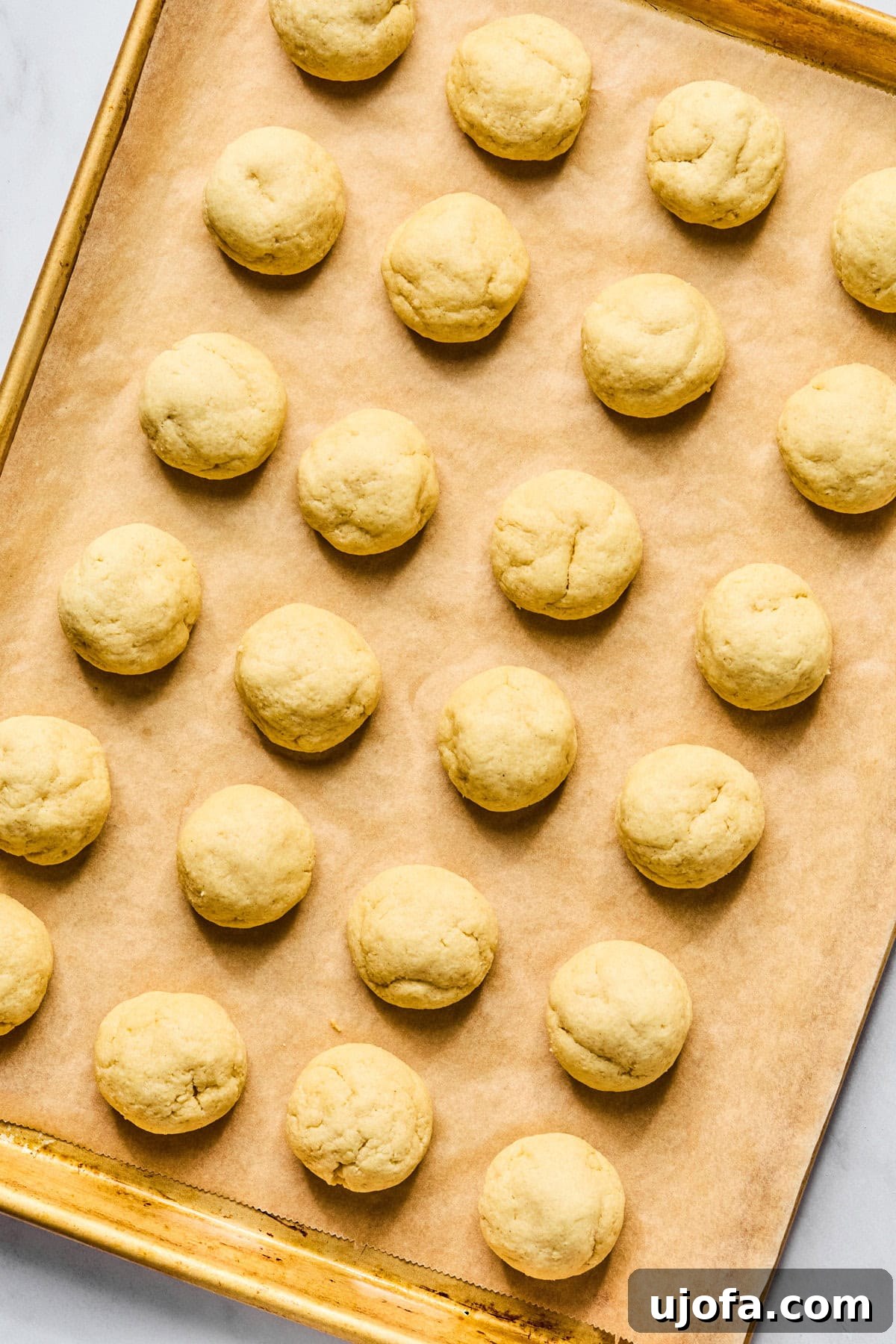 Sweet Traditions: Gluten-Free Italian Wedding Cookies 10 Baked gluten free Italian wedding cookies cooling on the parchment lined baking sheet.